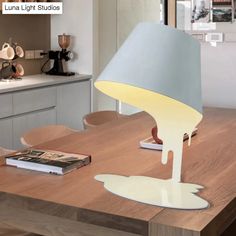 a table with a lamp on top of it and a book sitting next to it