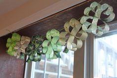 some paper shamrocks are hanging on the window sill