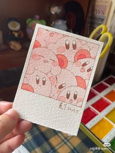 a hand holding up a card with an image of pigs on it