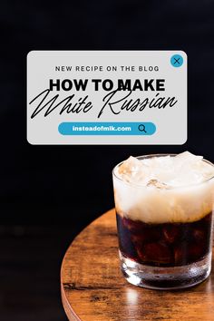 a drink sitting on top of a wooden table next to a sign that says how to make white russian