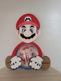 a paper mario doll sitting on top of a wooden shelf