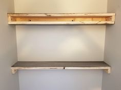 two wooden shelves in the corner of a room