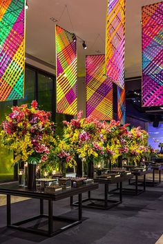 a group of vases filled with flowers sitting next to each other on top of tables