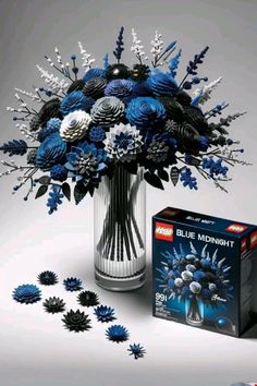 a bouquet of blue flowers in a vase next to a box of blu - ray magnets