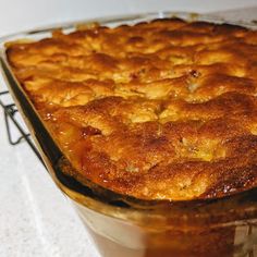 a casserole dish filled with food on top of a white tablecloth covered counter