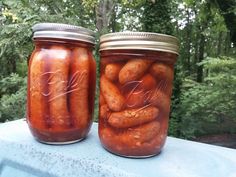 two jars filled with pickled carrots sitting on top of a blue table cloth