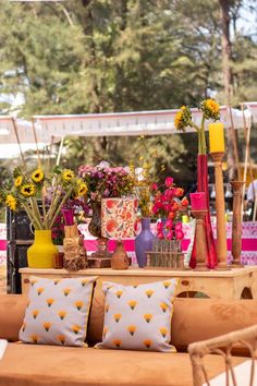 an outdoor seating area with flowers and vases on it