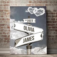 a street sign with two hearts shaped clouds above it