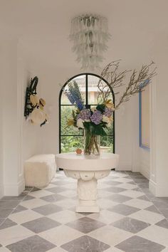 a bathroom with a checkered floor, chandelier and large window in it