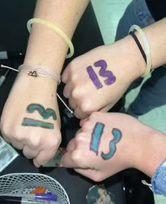 two people holding hands with numbers painted on them