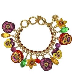 Ritzy Couture Multi Color Pansy Charm Adjustable Toggle Bracelet (Goldtone) Add a pop of spring to your outfit with this adorable accessory! This goldtone cable link bracelet features large double-sided flower drops, decorated with vibrant enamel colors of purple, yellow, green and red. Multi color glass bead drops and a thin strand of purple glass beads both accent and complement the bracelet. Use the toggle clasp to adjust this big and bold bracelet between three different sizes to find the perfect length that works for you. Goldtone Adjustable and fits most. Measures approximately 7.5” to 8.25" length Ritzy Couture by Esme Hecht – Original Designer of Lunch at The Ritz™ Designed with love in the USA Imported The signature is "Ritzy by Esme". Created by Esme Hecht - Original Creator and Toggle Bracelet, Purple Glass, Toggle Clasp, Bracelets And Charms, Pansies, Glass Bead, Link Bracelets, Fashion Watches, Glass Beads