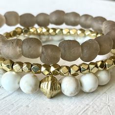 "This beautiful neutral beachy stack has just the right amount of sparkle and style and is the definition of beach chic! Neutral enough to wear with anything, classy enough to dress up and casual enough to wear anywhere! This trio is made with a 9mm sandy taupe 'sea glass' bracelet (from our very popular midi & chunky Sea Glass lines), 4mm faceted gold bracelet and 8mm white and tan magnesite gemstone bracelet.  Our Golden Sands stack would make a gorgeous wedding festivities look! It is a perfectly beachy~boho~neutral and would make a great gift too.   *Approximate length 7.25 inches (for an average 6.5-7\" wrist). Make a note in checkout to size up or down if preferred. *Comes gift-giving-ready with a Salty Sunshine branded tag, crinkle paper and a seafoam draw string bag. *Free shipping Elegant Adjustable Beaded Bracelets For Vacation, Elegant Adjustable Beaded Bracelet For Vacation, Elegant Adjustable Jewelry For Beach Season, Adjustable Sand-colored Jewelry For Summer, Gold Beaded Bracelets For Beach Season, Bohemian Gold Beaded Bracelets For Vacation, Gold Bohemian Beaded Bracelets For Vacation, Summer Beach Stackable Jewelry, Elegant Beige Beach Bracelet