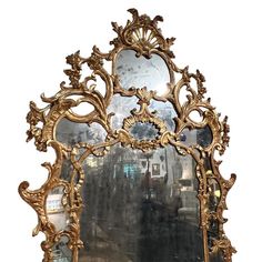 an ornate gold framed mirror on a white wall