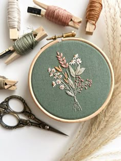 the embroidery is being worked on with scissors and thread, along with other crafting supplies