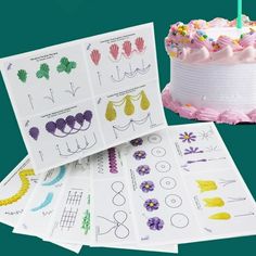 a birthday cake with lots of stickers on it next to some cards and a cupcake