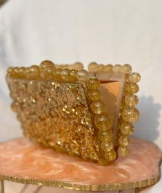 About This Item: Introducing our Handmade Resin Beaded Bridal Clutch Bag, a perfect blend of elegance and uniqueness for your special day. This beautiful clutch features exquisite resin beads and a chic gold chain, making it an essential accessory for any bride. Key Features: Material: High-quality resin beads Chain: Elegant gold chain for added style Design: Handmade with meticulous attention to detail Dimensions: Perfect size to hold your wedding day essentials Versatility: Ideal for weddings, receptions, and other special occasions Color Variant: Golden Glitter, White, Green, Pink Peach, Ivory Why You'll Love It: This bridal clutch bag is not just an accessory; it's a statement piece. The intricate resin beading adds a touch of sophistication, while the gold chain provides a modern twis Elegant Handmade Luxury Box Bag, Gold Clutch Box Bag For Wedding, Gold Square Box Bag For Wedding, Gold Rectangular Case Bag For Wedding, Gold Rectangular Box Bag For Party, Glamorous Gold Rectangular Box Bag, Gold Box Bag With Pearl Handle For Evening, Gold Clutch With Pearl Handle As Gift, Gold Rectangular Case Clutch For Gift