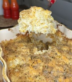 a person is lifting a piece of cheese casserole out of the dish with a spatula