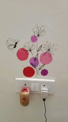 an electrical outlet is plugged in to a wall with flowers painted on the wall