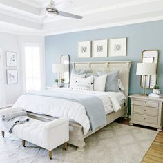 a bedroom with blue walls, white furniture and a large bed in the center of the room