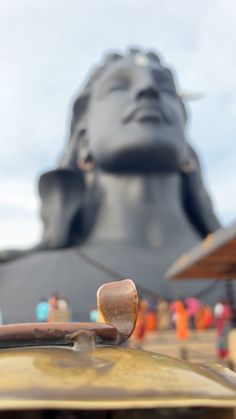 a close up of a car with a statue in the background