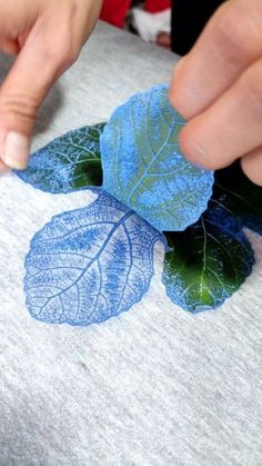 someone is cutting out leaves on a t - shirt