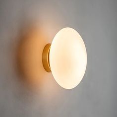 a light that is on the wall with a white ball attached to it's side