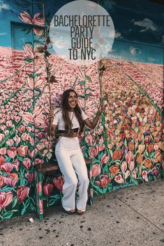 a woman standing in front of a flowered wall with the words bachelor party guide to nyc