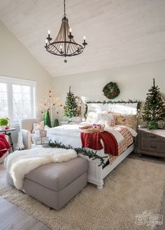 a bedroom decorated for christmas with white furniture