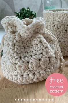 two crocheted bags sitting on top of a wooden table next to each other