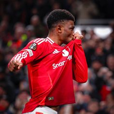 a soccer player wiping his face with his hands while standing in front of an audience