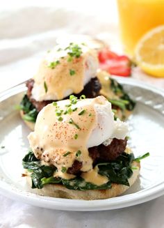 two eggs benedicts on toast with spinach and tomatoes