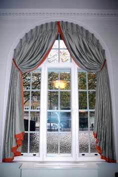 an open window with curtains hanging on the side