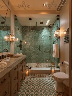 a bathroom with green tiled walls and flooring next to a walk - in shower