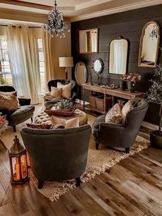 a living room filled with furniture and a chandelier hanging from the ceiling over a wooden floor