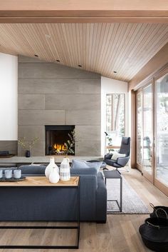 a living room with a couch, coffee table and fire place in the middle of it