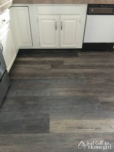 a kitchen with white cabinets and wood flooring on the walls is pictured in this image