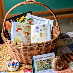 a basket filled with books sitting on top of a table next to a bowl of candy