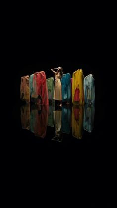 several colorful pieces of clothing sitting on top of a black surface with water reflecting in it