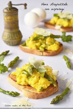 there are many small pieces of bread with food on it and some asparagus