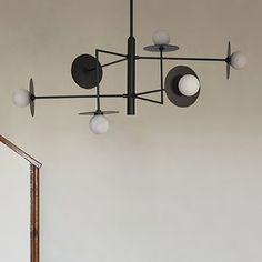 a chandelier hanging from the ceiling in a room with white walls and flooring