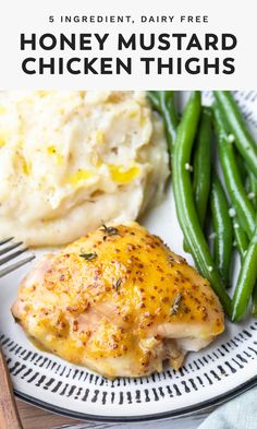 a white plate topped with chicken, mashed potatoes and green beans next to a fork