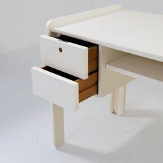 a white desk with two drawers on it's side and one drawer open to show the contents