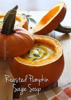 roasted pumpkin sage soup in a bowl on a cutting board with two halves cut open