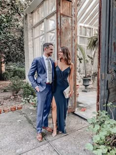 a man and woman standing next to each other in front of an open glass door