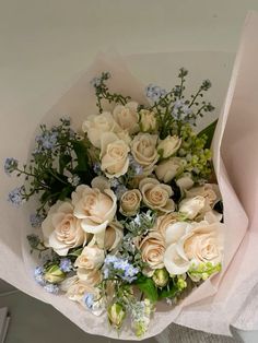 a bouquet of white roses and blue flowers