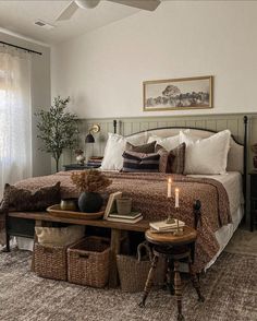 a bedroom with a bed, table and two baskets on the floor next to it