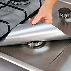 a person is touching the side of a stove with a sheet on it's burner