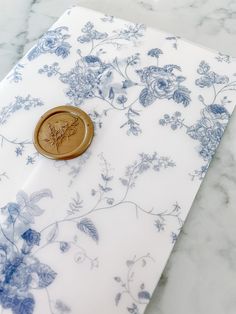 a wooden button sitting on top of a blue and white flowered paper