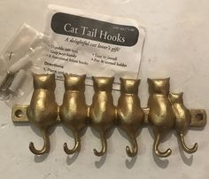 five gold cat tail hooks are sitting on a table