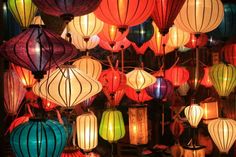 many colorful lanterns are hanging from the ceiling